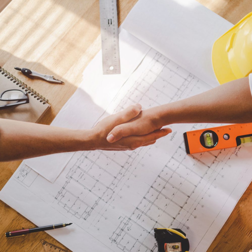 top view construction worker team contractor hand shake after finishing up business meeting to greeting start up project contract in construction site building, teamwork, partnership, industry concept